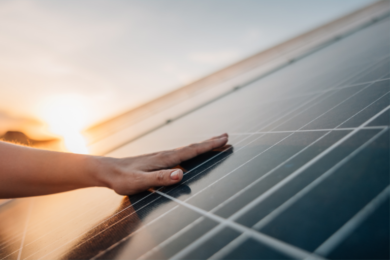 Hand touching solar panel.