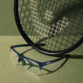 Pair of blue glasses sitting on bench sitting next to black tennis racquet